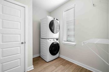 A white front loading washing machine in a laundry room.
