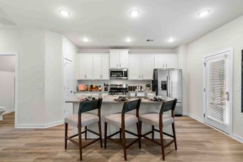 A kitchen with a table and chairs in the middle of the room.