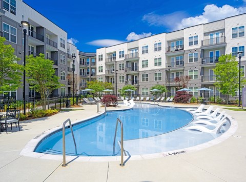 A swimming pool in front of apartment buildings.