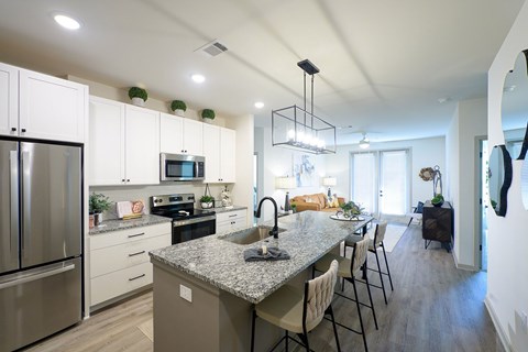 A modern kitchen with granite countertops and stainless steel appliances.