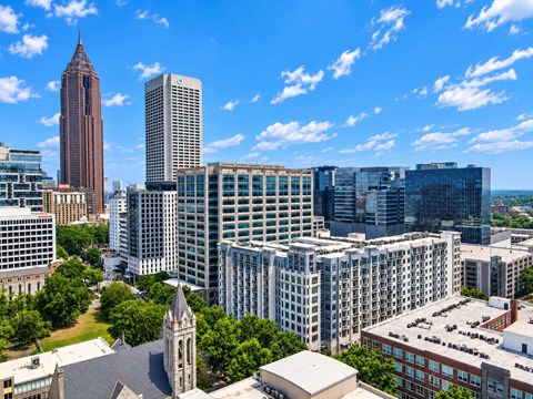 A cityscape with a mix of modern and older buildings under a clear blue sky.