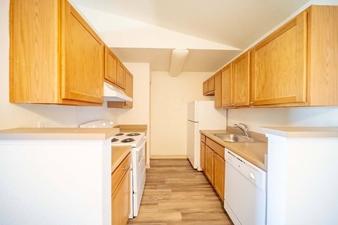 A kitchen with wooden cabinets and white appliances.