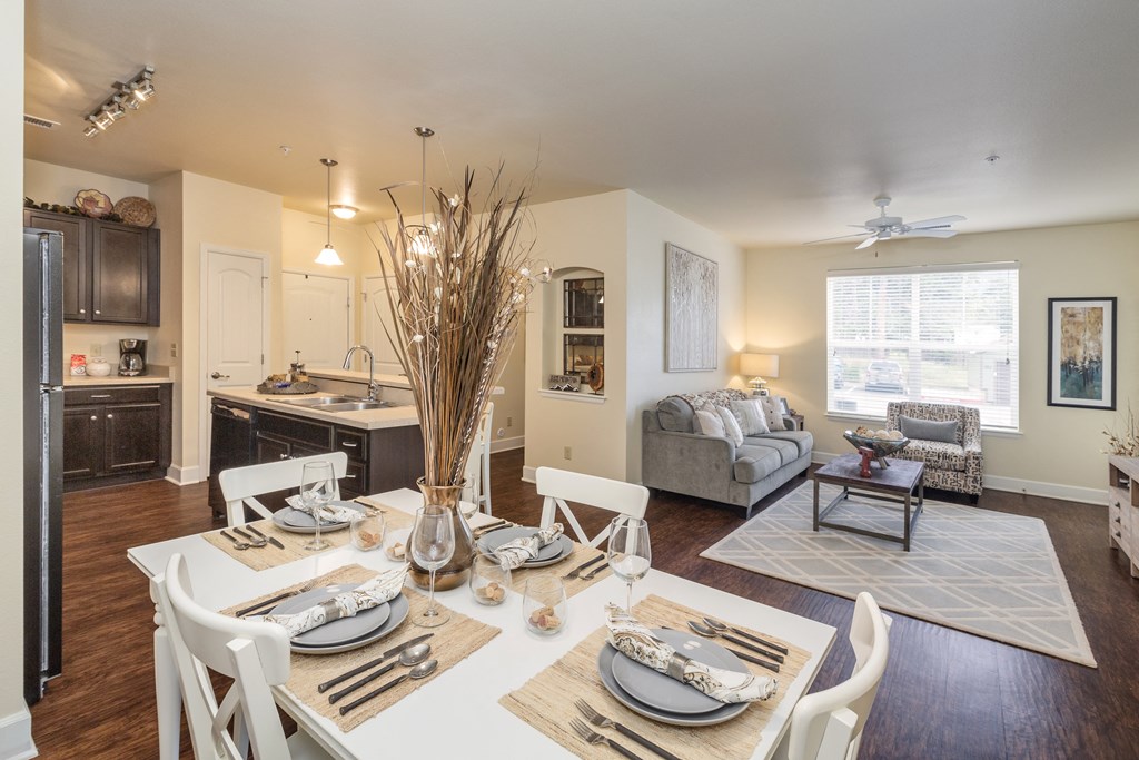 a living room and dining room with a table and chairs