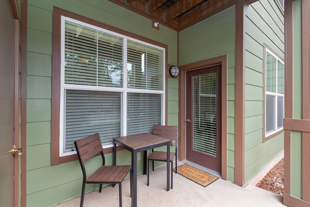 a patio with two chairs and a table on a porch