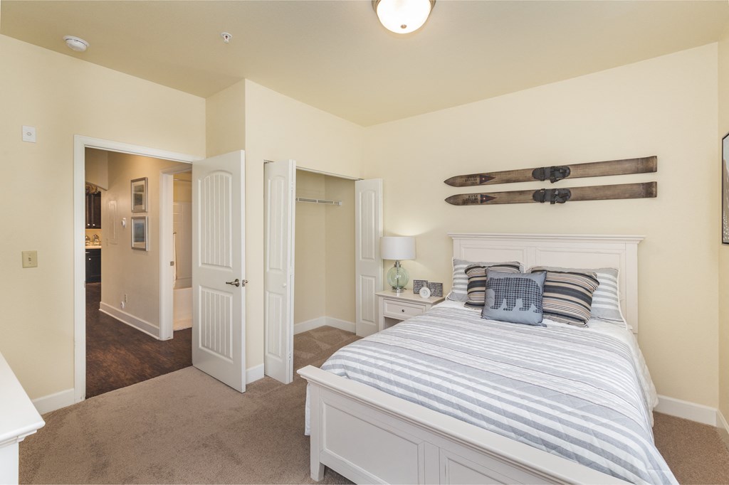 a bedroom with a bed and a closet and a bathroom