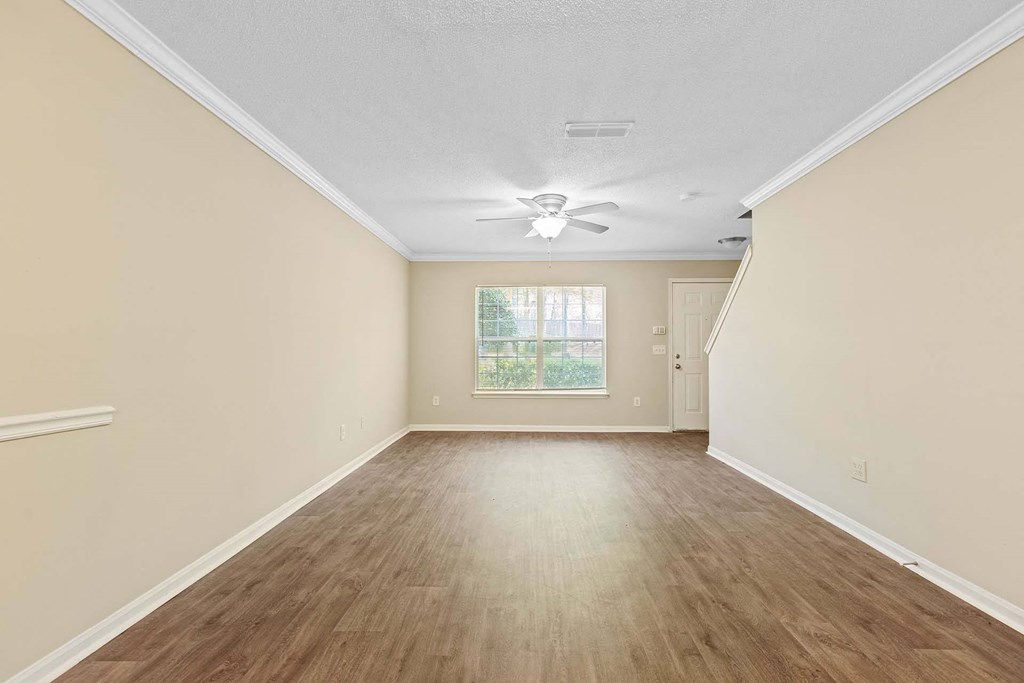 A room with wooden flooring and a ceiling fan.