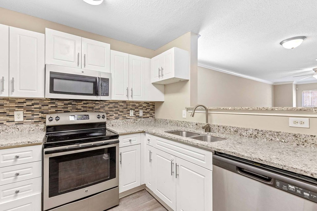 A kitchen with white cabinets and a black stove top oven.