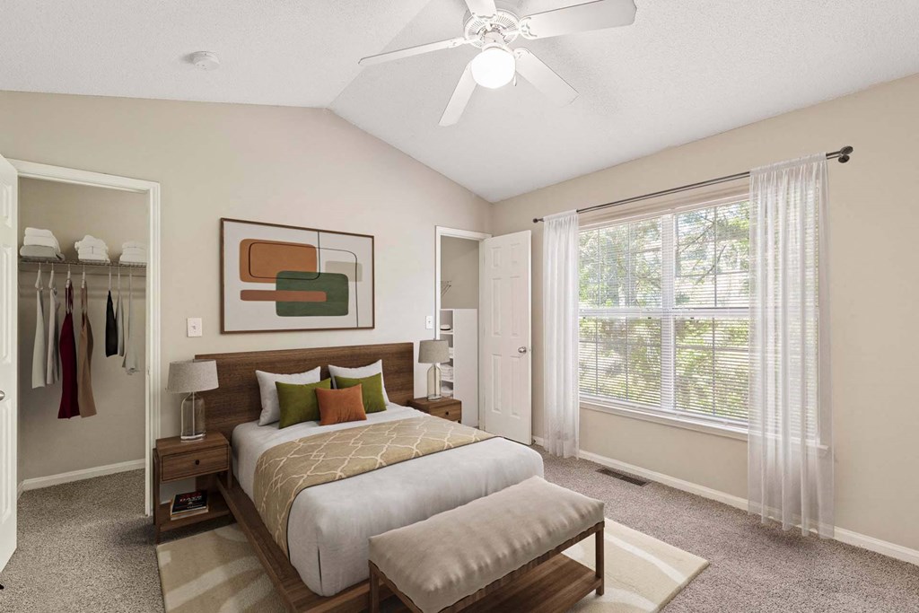 A bedroom with a large bed and a ceiling fan.