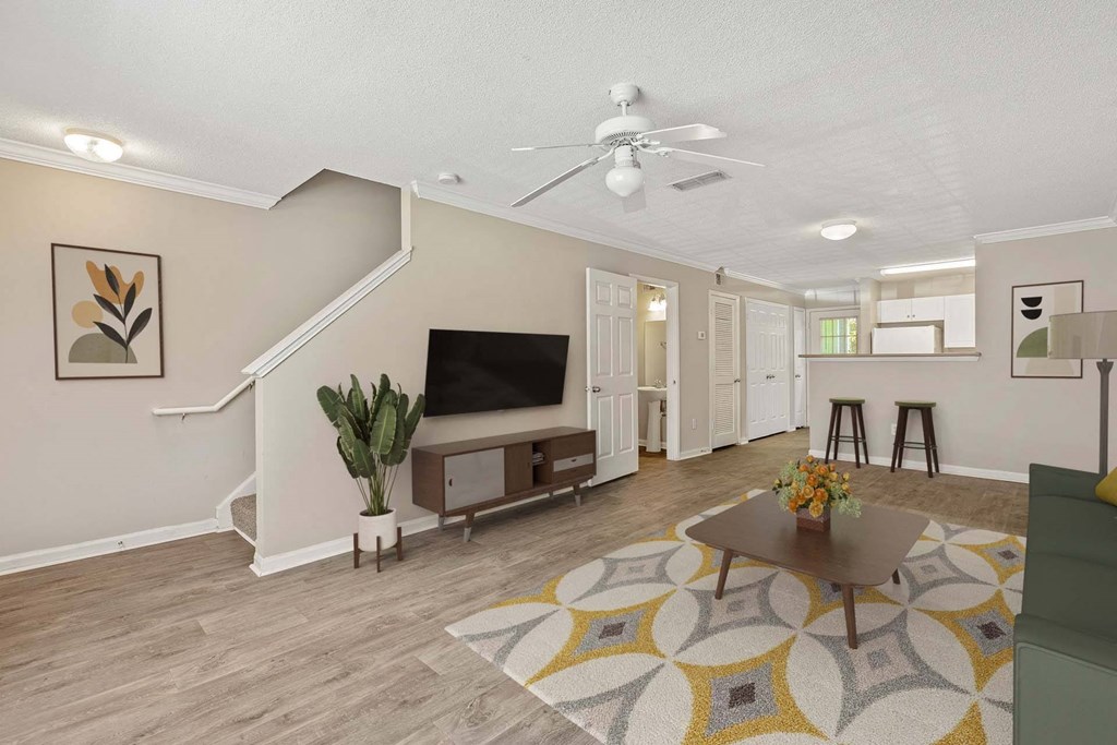 A living room with a staircase and a television.