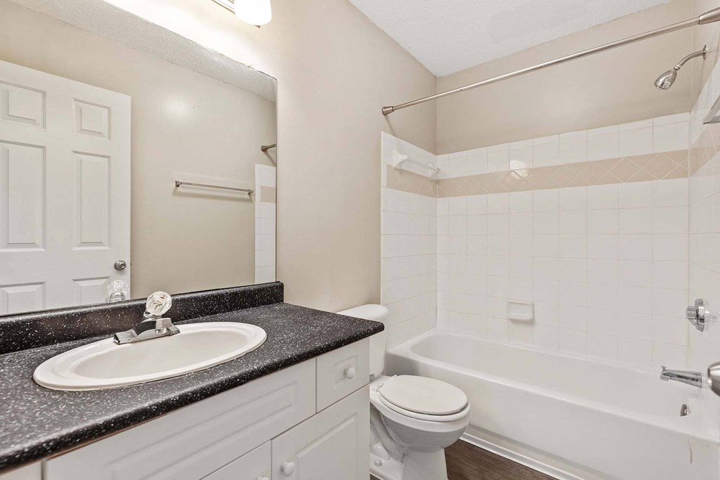 A bathroom with a sink, toilet, and bathtub.