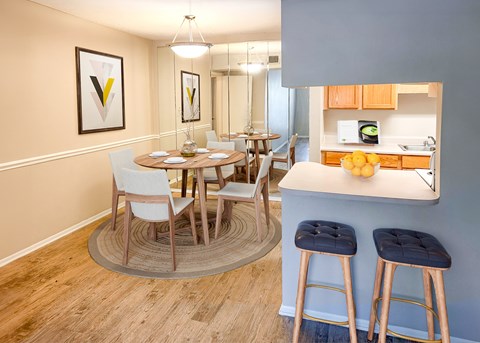 A kitchen with a dining table and chairs.