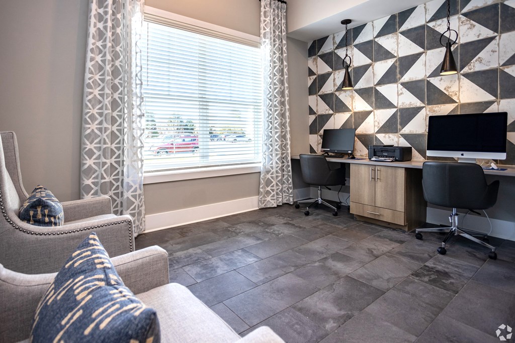 a room with a desk and two chairs and a couch