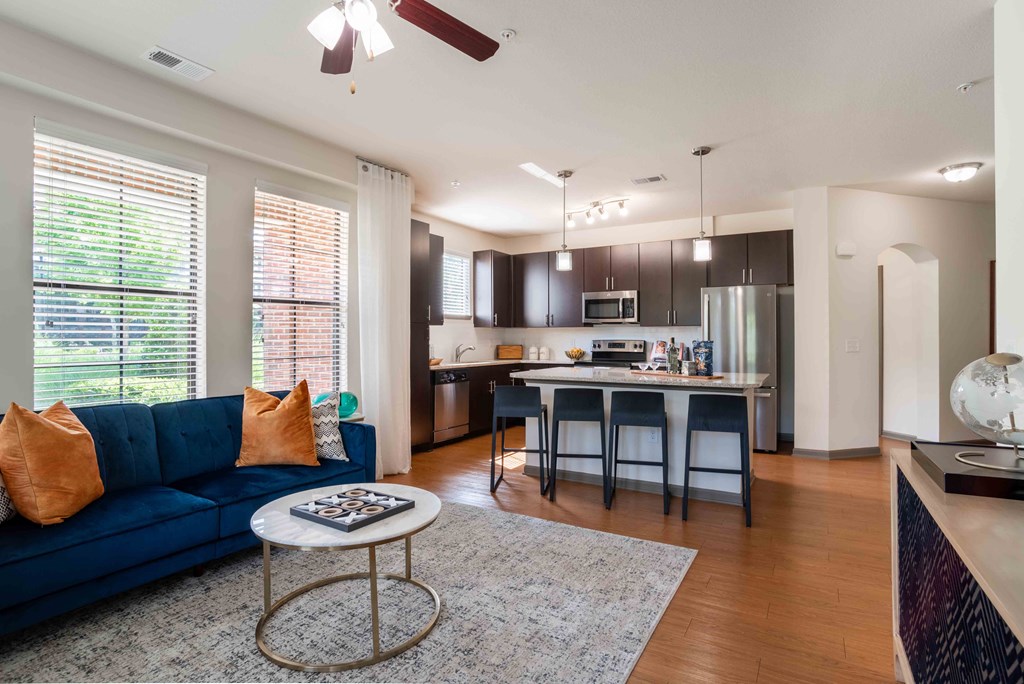 Greenville, SC Pet-Friendly Apartments - Velo Verdae - Living Room with Wood-Style Flooring, an Open Layout, and Kitchen Area