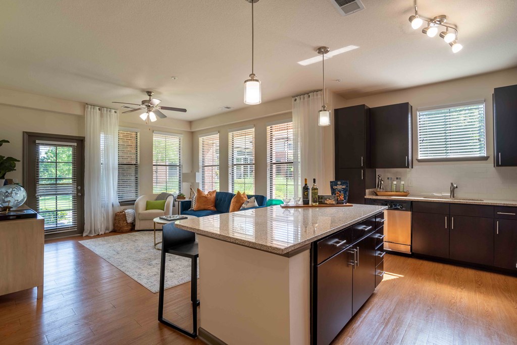 an open kitchen and living room with a large counter top