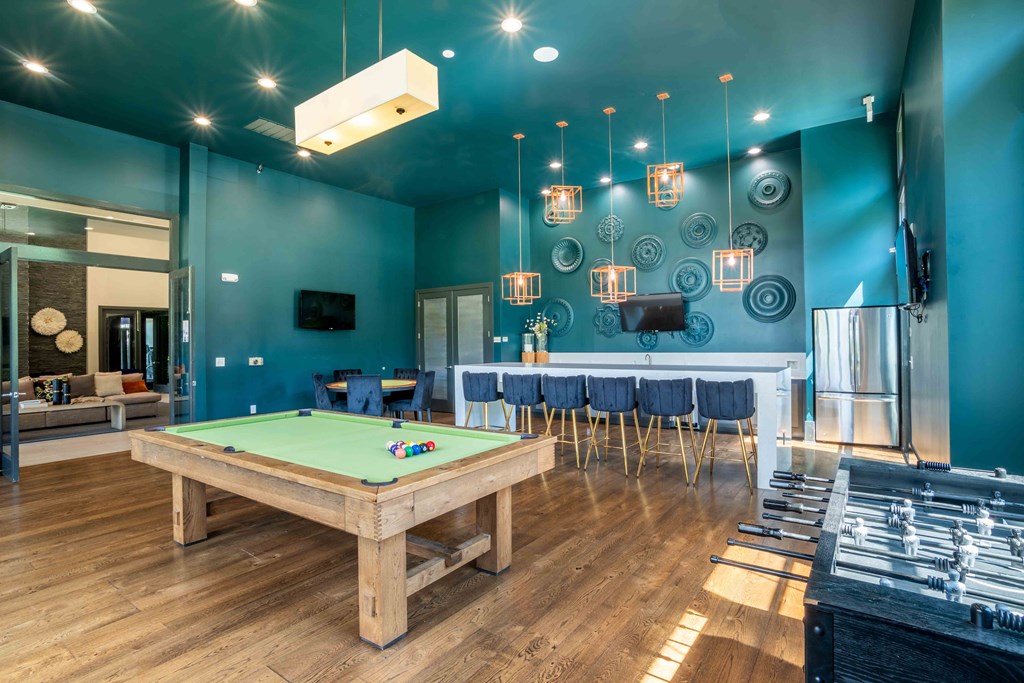a game room with a pool table and a bar