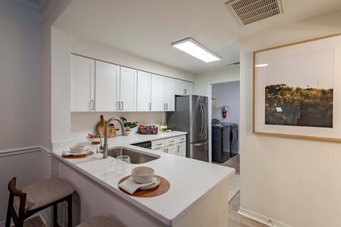 A kitchen with white cabinets and a white counter top.