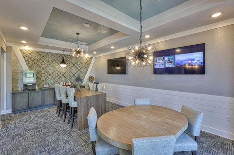 A modern dining room with a wooden table and grey chairs.