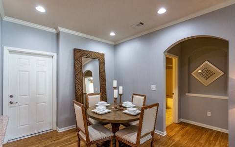 a dining room with a table and chairs and a mirror