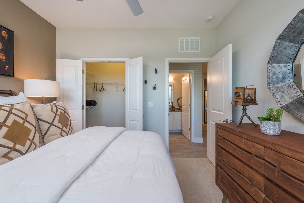 a bedroom with a bed and a dresser and a bathroom