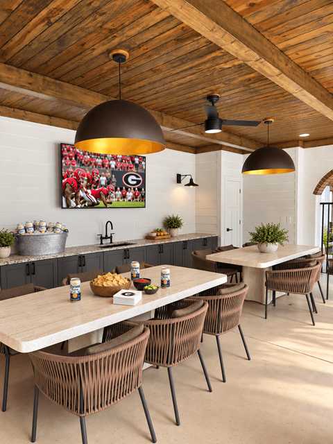 A modern dining room with a wooden ceiling and a large painting of a football game on the wall.