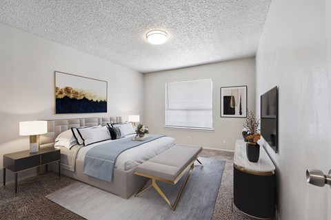 A bedroom with a large bed and a painting on the wall.
