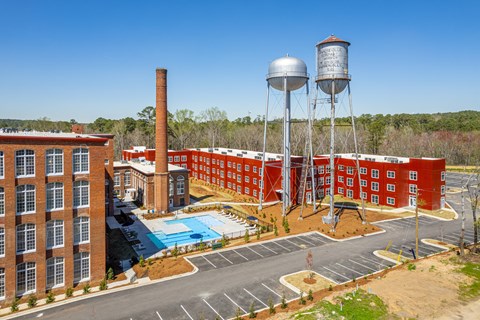 A red brick building with a water tower and a pool.