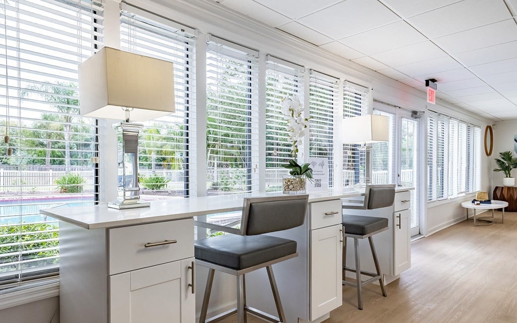 A kitchen with white cabinets and a bar area with stools at Waterview at Rocky Point, Tampa, FL