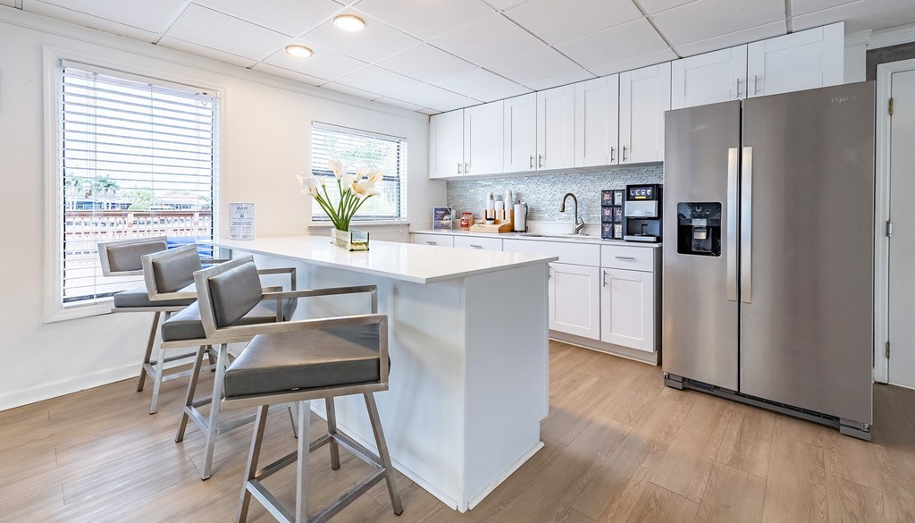 A kitchen with a white island and a refrigerator at Waterview at Rocky Point, Tampa, FL