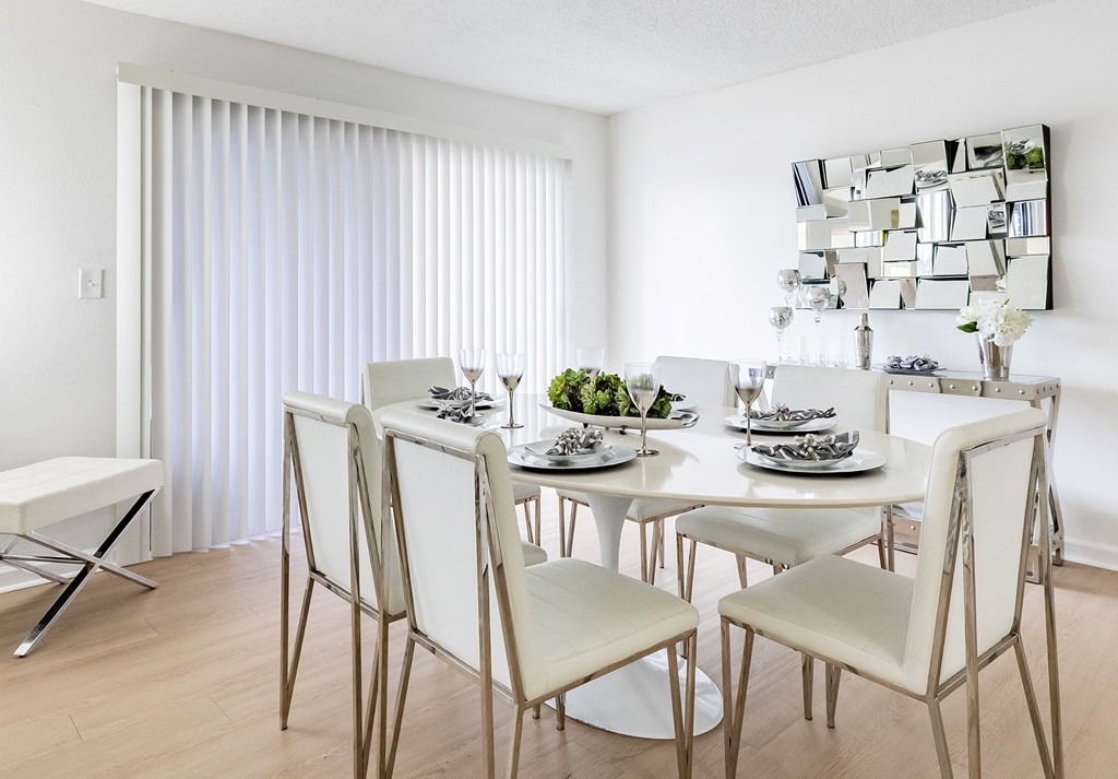 A modern dining room with a white table and chairs at Waterview at Rocky Point, Tampa, FL