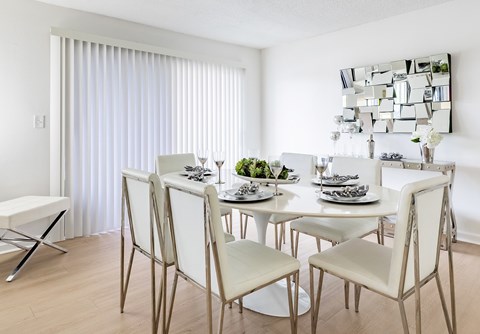 A modern dining room with a white table and chairs at Waterview at Rocky Point, Tampa, FL