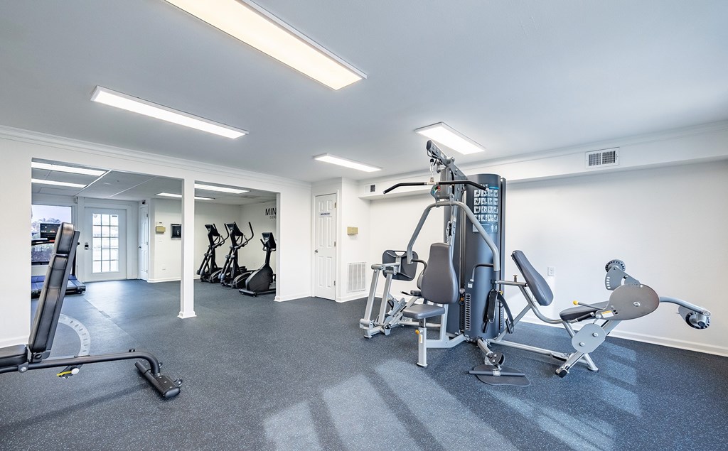 A gym with a variety of equipment including a treadmill, stationary bike, and weight machines at Waterview at Rocky Point, Tampa, FL