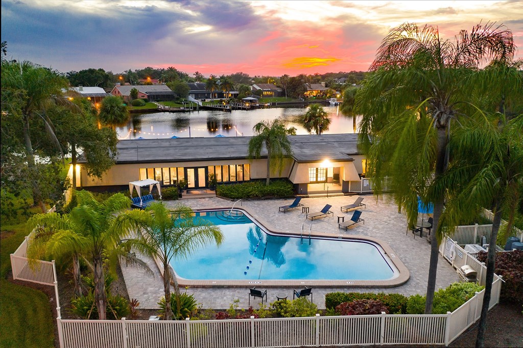 an aerial view of a resort style swimming pool with palm trees and a building in the background at Waterview at Rocky Point, Tampa Florida