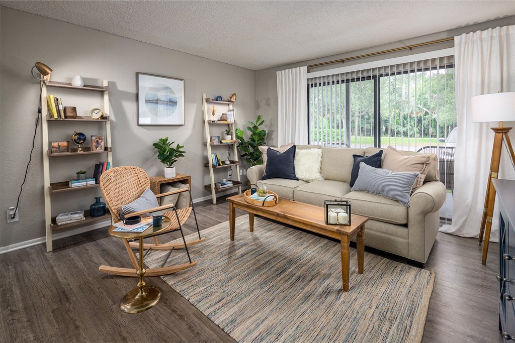 a living room with a couch and a chair in front of a sliding glass door  at Waterview at Rocky Point, Florida, 33634