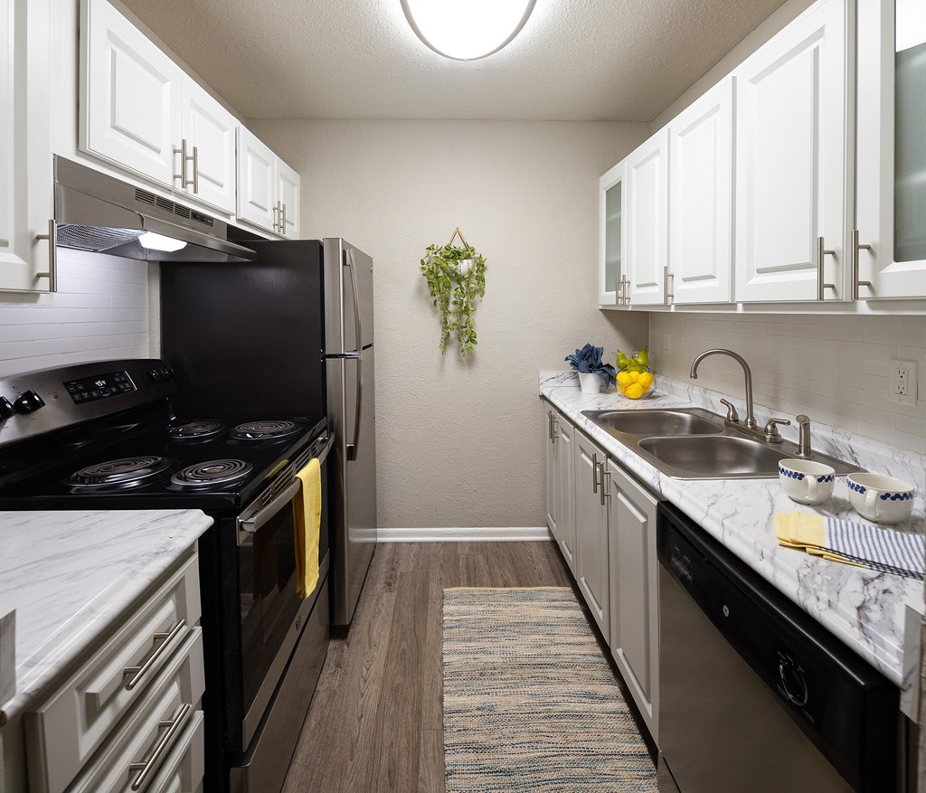 a kitchen with white cabinets and a black stove top oven  at Waterview at Rocky Point, Tampa