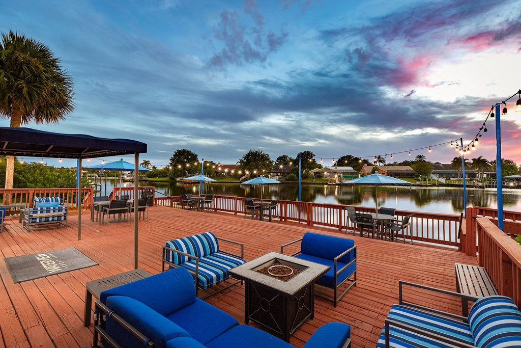 a deck with blue couches and chairs overlooking a body of water at Waterview at Rocky Point, Tampa, FL