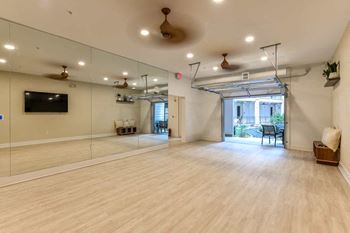 an empty room with a large mirror and a projection screen on the wall