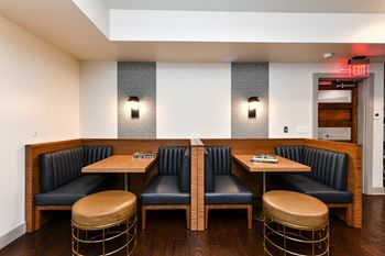 a seating area with black chairs and wooden tables