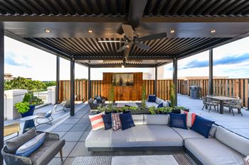 a covered patio with a couch and chairs