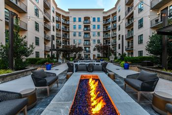 an outdoor patio with a firepit and lounge chairs