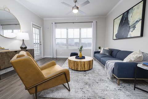 A living room with a yellow chair and a blue couch.