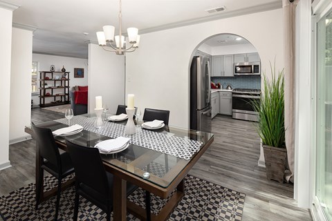 A modern dining room with a glass table and chairs.