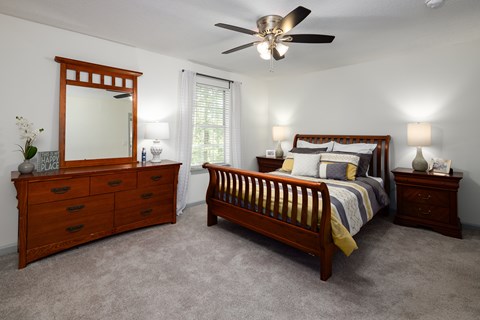 A bedroom with a bed, dresser, and mirror.