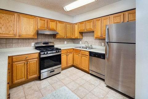 A kitchen with wooden cabinets and stainless steel appliances.