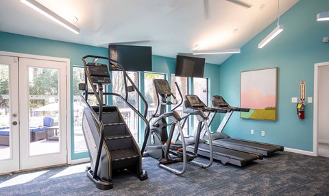 A gym with treadmills, elliptical machines, and a stair climber.