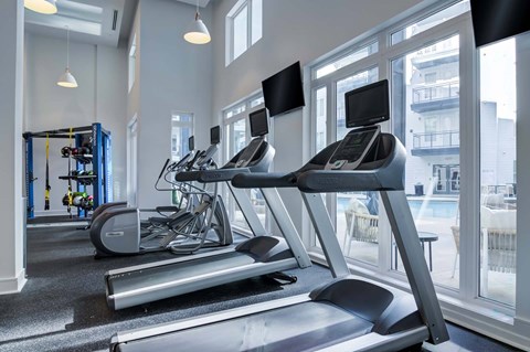 A gym with treadmills, exercise bikes, and other equipment.