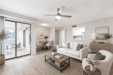 A living room with a white couch, a coffee table, and a ceiling fan.