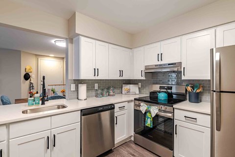 A kitchen with white cabinets and stainless steel appliances.
