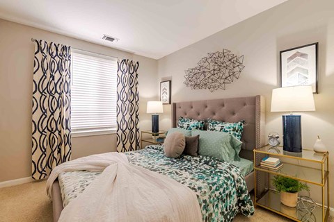 A bedroom with a large bed and a decorative wall hanging.