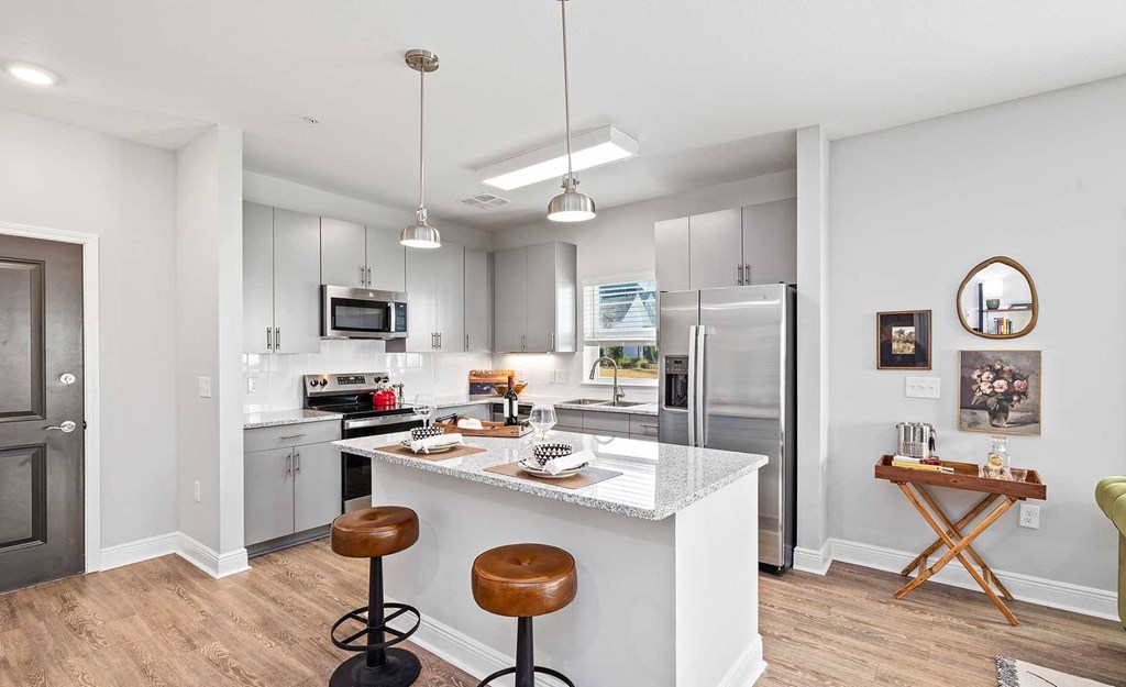 A kitchen with a white island and a refrigerator.