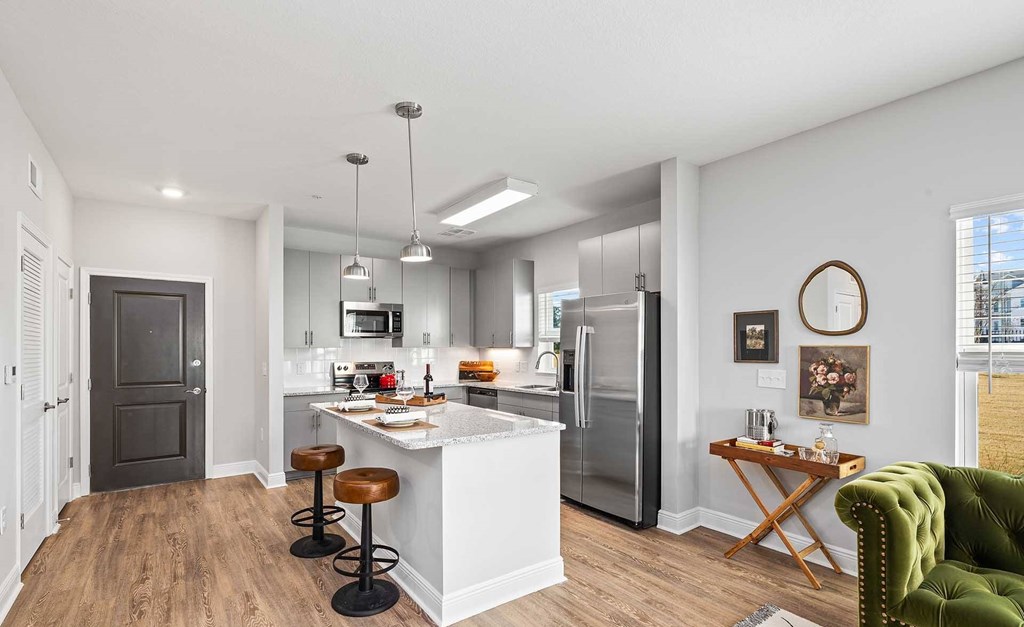 A modern kitchen with a white island and stools.